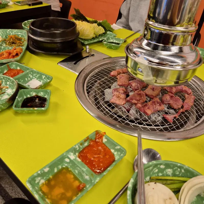 맛있게 구워진 고기를 상추에 싸서 먹는 모습