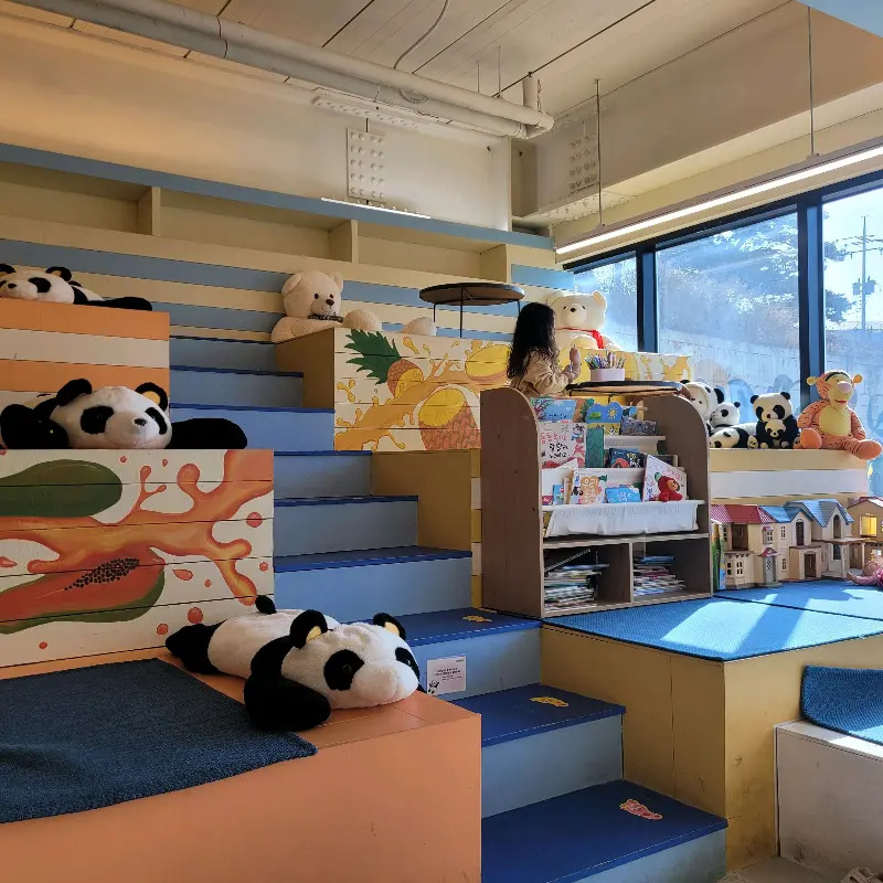 판다카페 내부 - 아이들이 놀 수 있는 계단식 공간과 책장