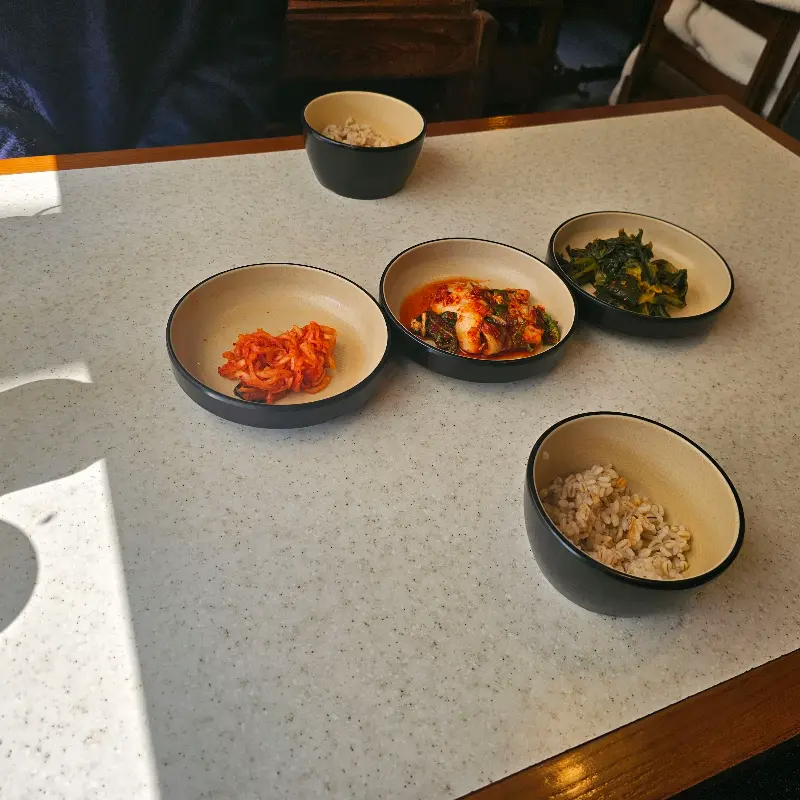 테이블 위에 놓인 옹심이와 곁들임 반찬