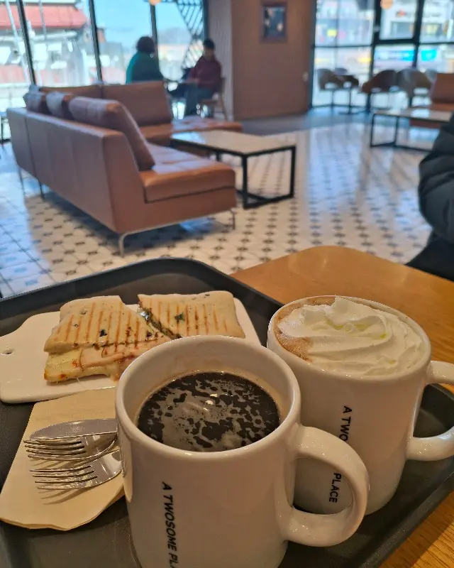 넓은 창밖으로 햇살이 가득 들어오는 투썸플레이스 내부