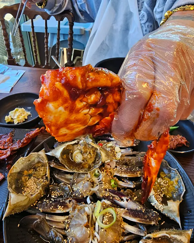 양념게장을 손으로 들고 먹는 모습