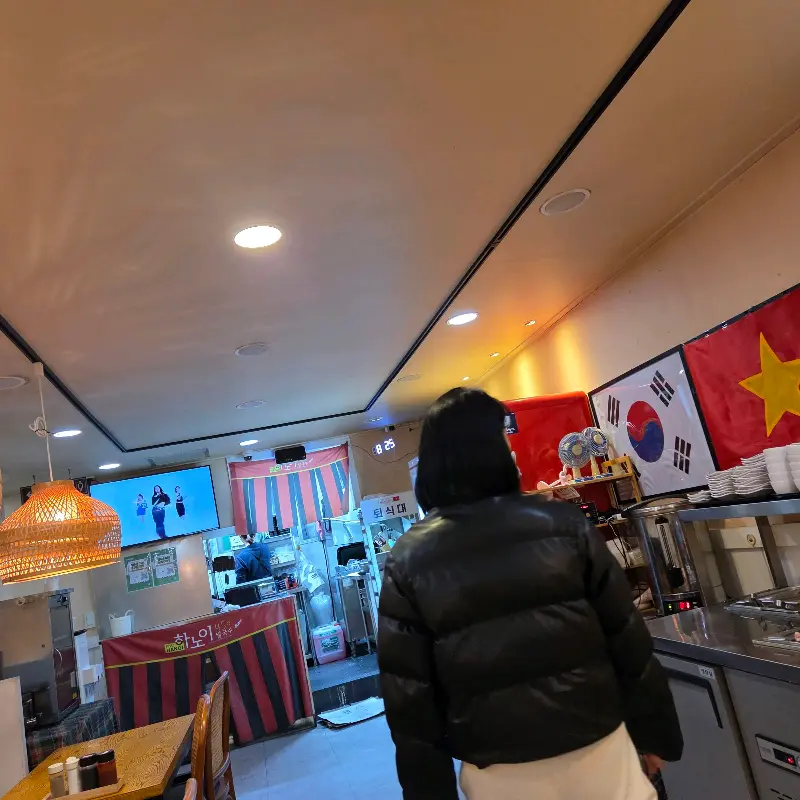 하노이450 내부 모습. 테이블 위에는 식기류와 소스통이 놓여져 있고, 벽에는 메뉴 사진이 걸려있다.