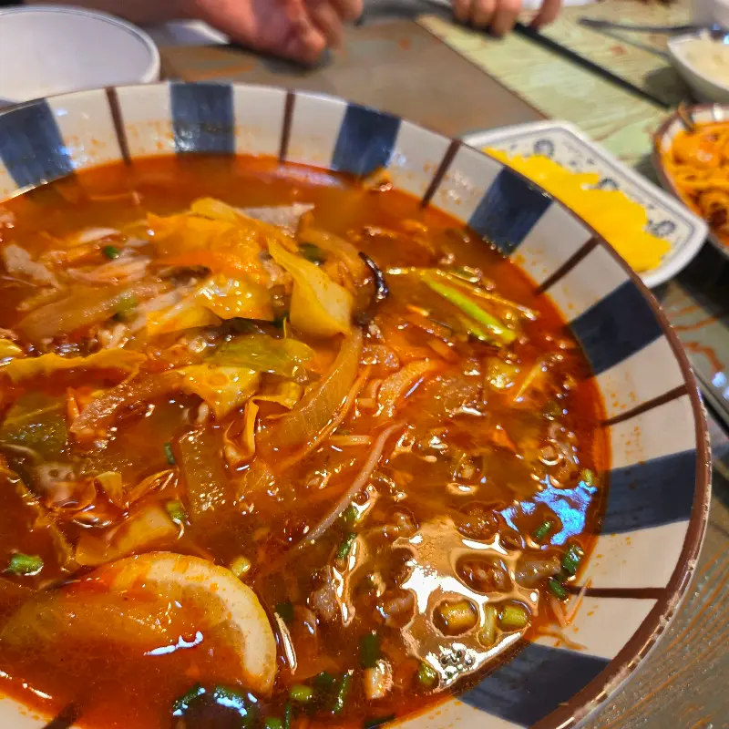 팟타이. 면 위에 숙주와 새우가 듬뿍 올려져 있고, 양배추 샐러드가 곁들여져 있다.