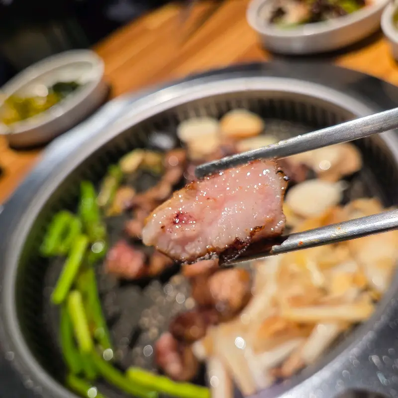 젓가락으로 집어 올린 잘 익은 목살 한 점