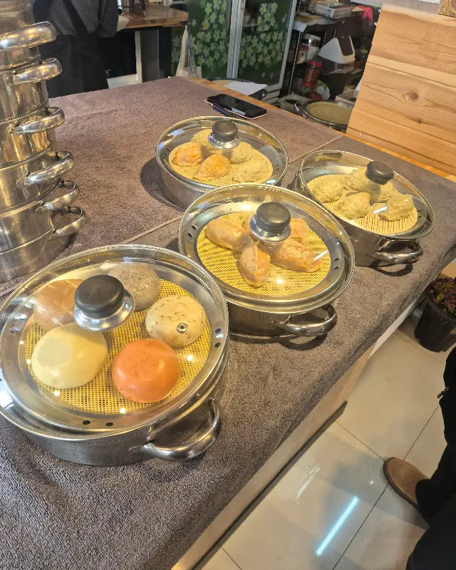 찜기에서 쪄지는 만두와 찐빵