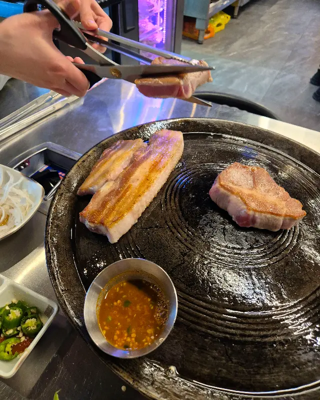 직원이 삼겹살을 잘라주는 모습