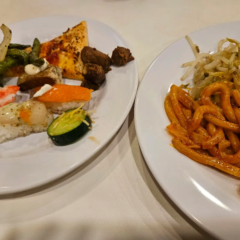 다양한 초밥과 볶음 우동이 담긴 접시