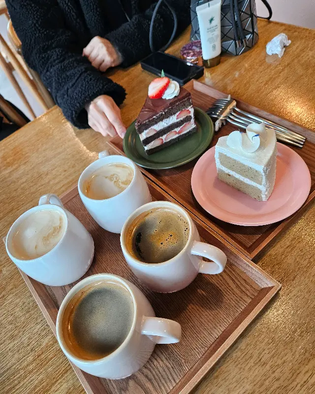 다양한 케이크와 커피가 함께 놓인 쟁반