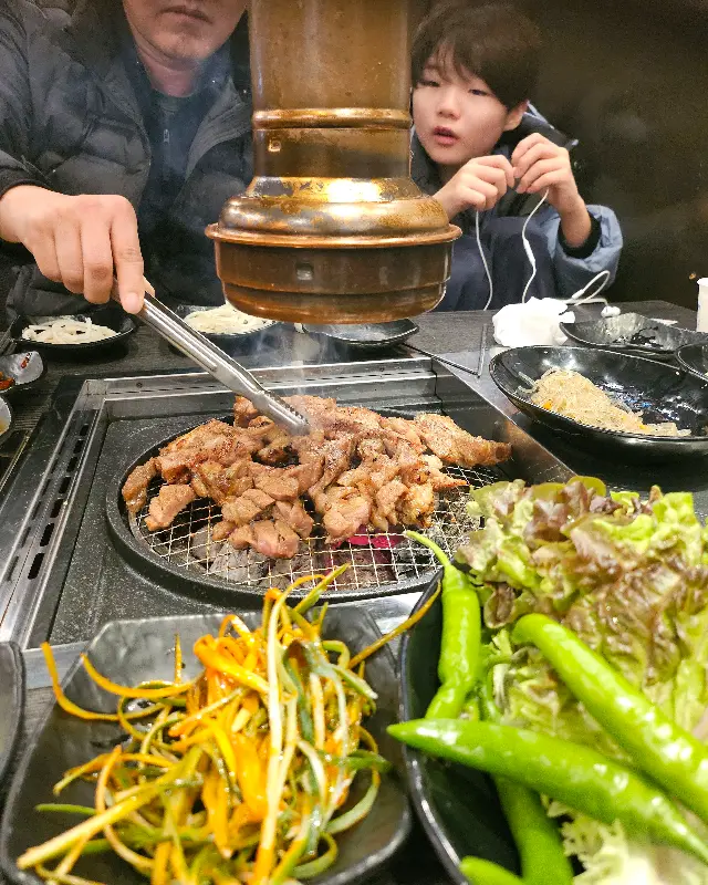 수제 돼지갈비가 불판 위에서 맛있게 구워지고 있는 모습