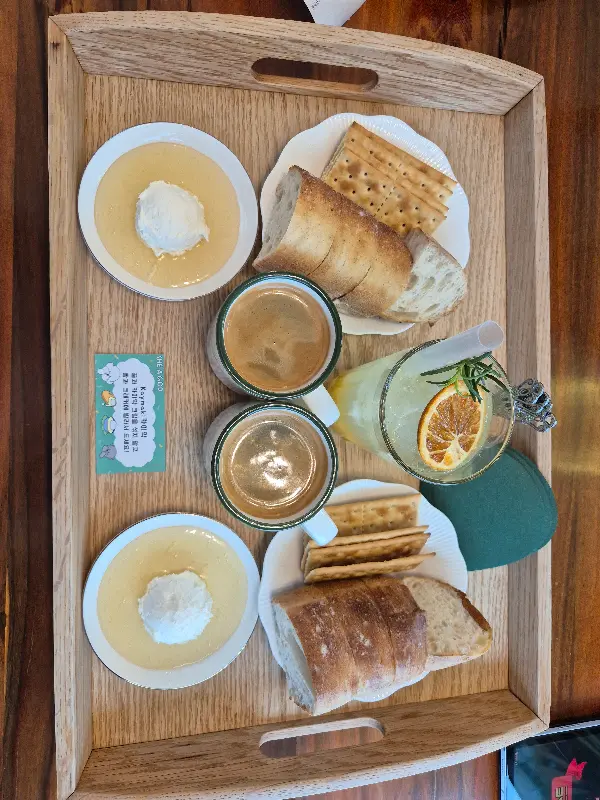 카이막, 빵, 음료가 나무 쟁반에 담겨 있는 모습