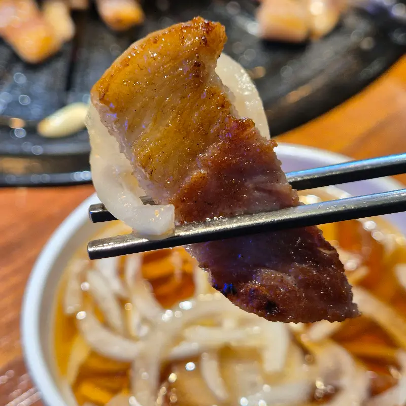 잘 구워진 고기를 양파절임과 함께