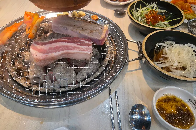 숯불 위에서 익어가는 두툼한 삼겹살