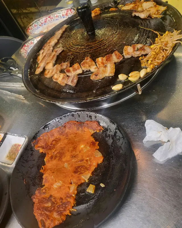 솥뚜껑 위에서 구워지는 김치와 삼겹살