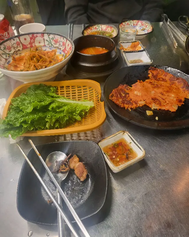 다채로운 밑반찬과 쌈 채소가 놓인 테이블