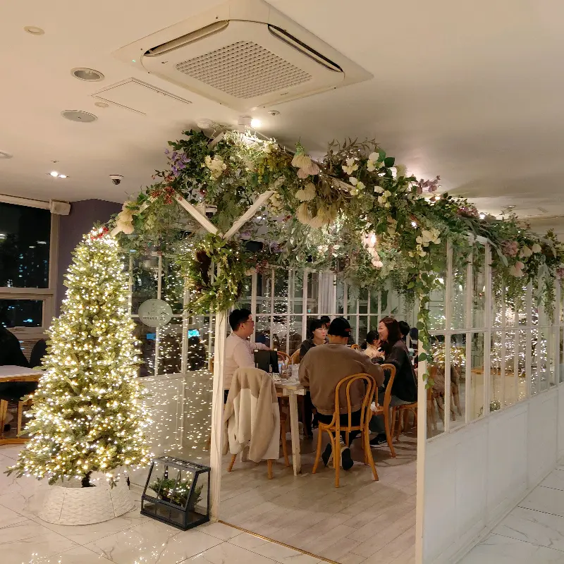 화려한 꽃 장식 아래에서 식사하는 사람들