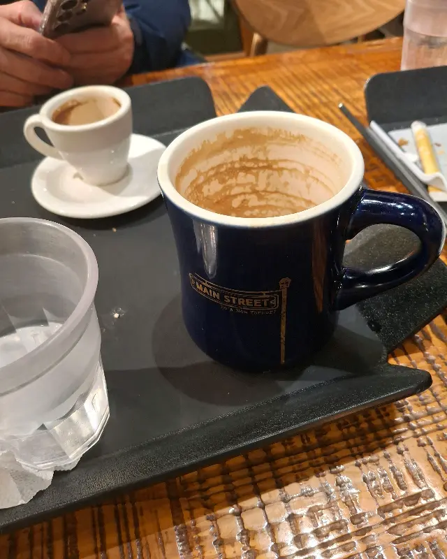 커피를 마신 후 빈 컵과 접시가 놓여 있는 사진