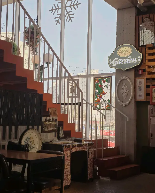 카페 내부의 계단과 장식품들이 보이는 사진