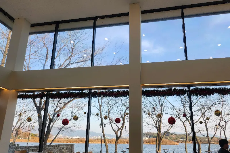 높은 천장과 넓은 창문이 인상적인 카페 내부