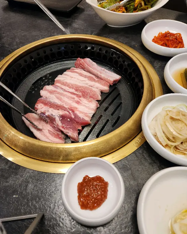 황금빛 불판 위에서 구워지는 삼겹살