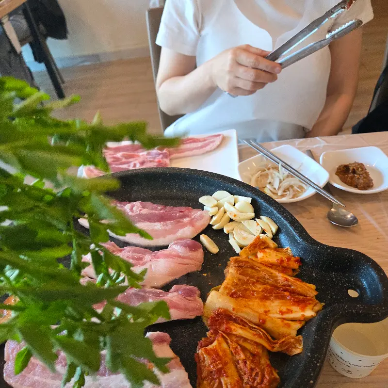 불판 위에 올려진 삼겹살과 김치