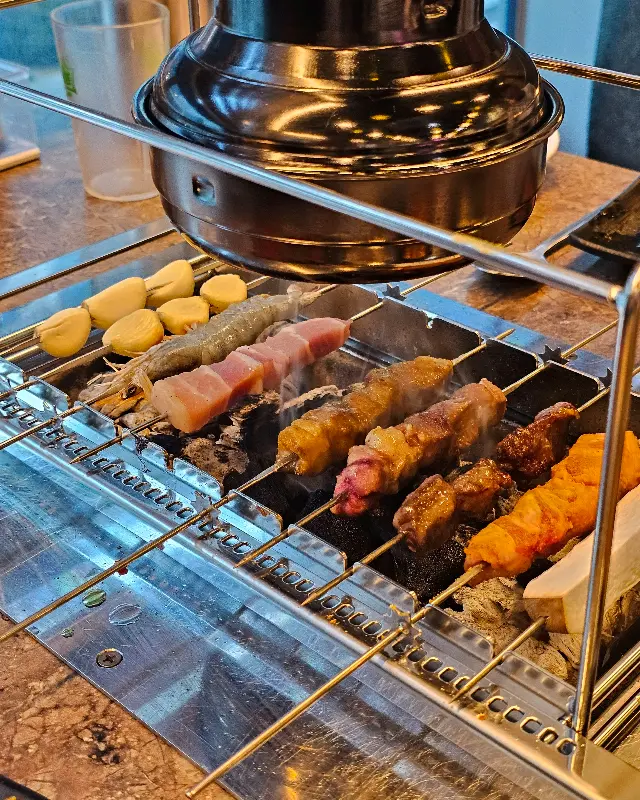 숯불 위에서 노릇하게 익어가는 양꼬치와 새우