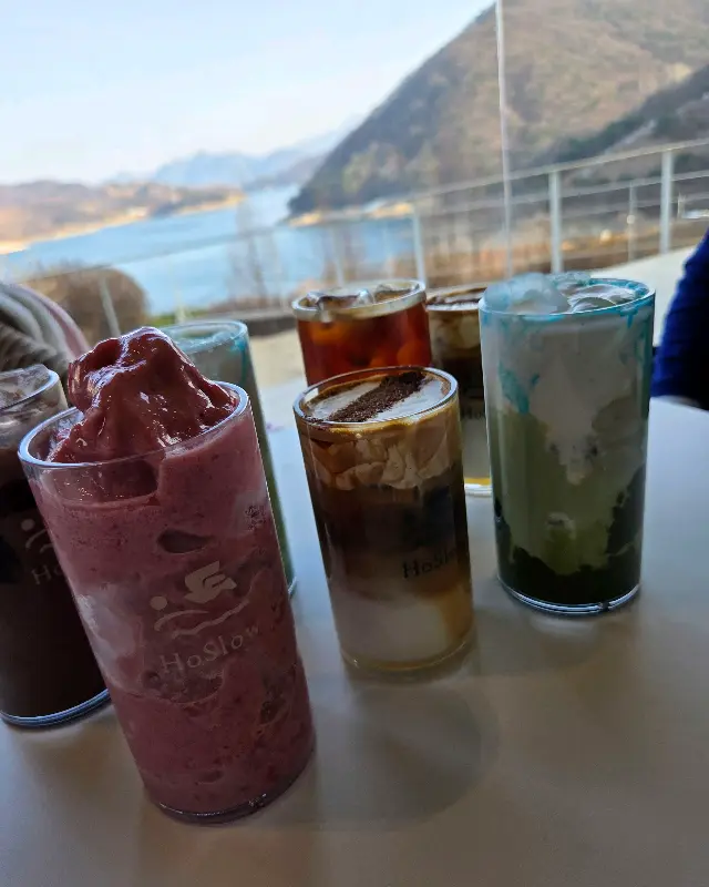 다양한 음료들이 놓인 테이블, 그 너머로 충주호가 보인다