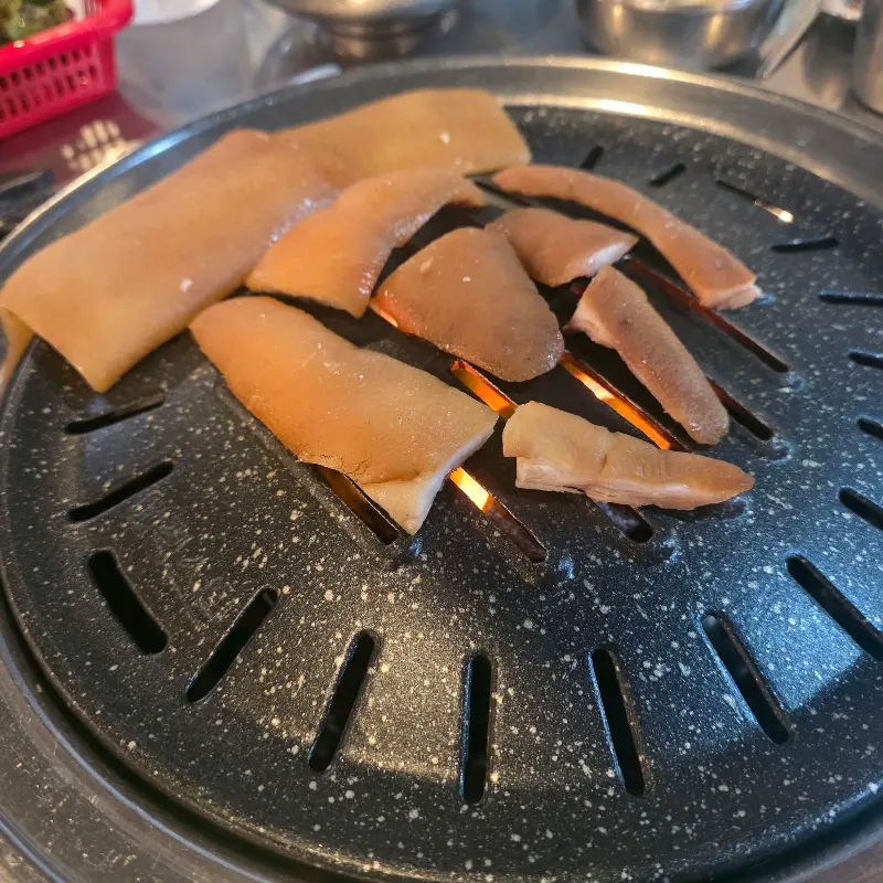 불판 위에 올려진 돼지 꼬리
