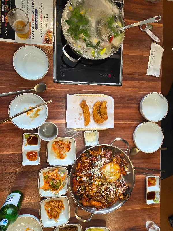 테이블 전체 샷. 아구찜, 아구탕, 아구튀김, 밑반찬 등이 푸짐하게 차려져 있다.