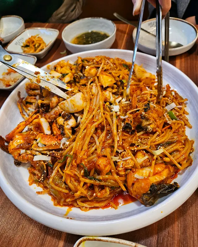 아구찜을 먹기 좋게 손질하는 모습. 쫄깃한 면발과 아구, 갑오징어가 푸짐하게 들어있다.