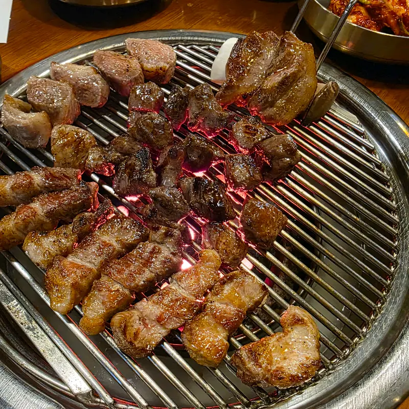 불판 위에서 노릇하게 익어가는 깍둑항정살