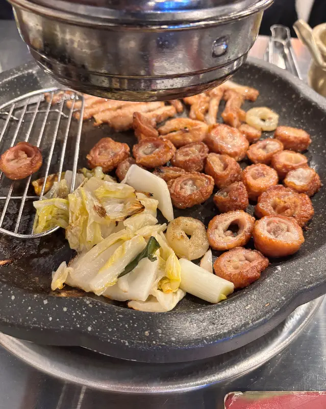 잘 익은 막창을 젓가락으로 집어올리는 모습