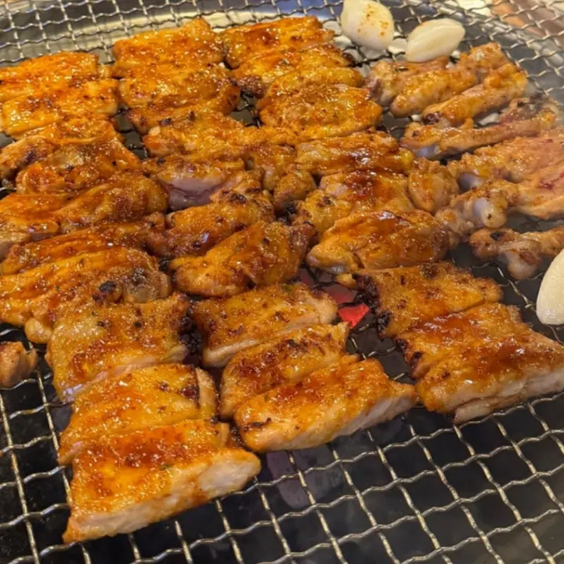 숯불 위에서 맛있게 구워진 닭갈비와 마늘