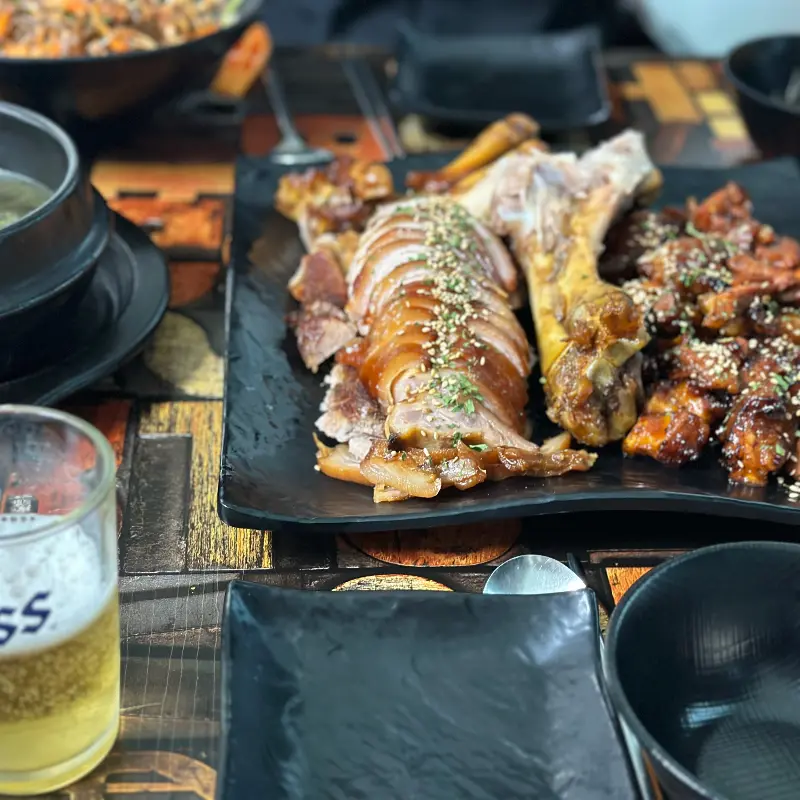 윤기가 자르르 흐르는 족발과 불족발이 검은색 접시에 담겨 있다.