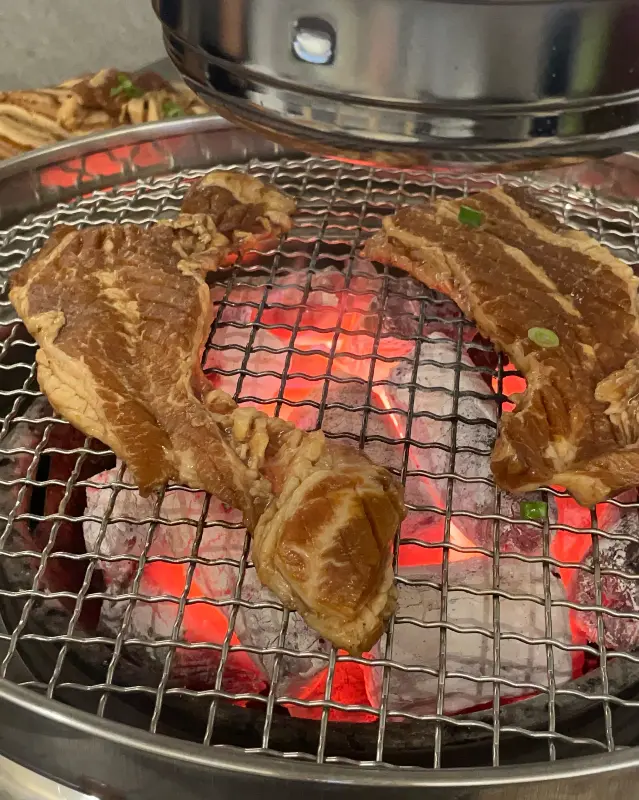 숯불 위에서 노릇하게 익어가는 돼지갈비