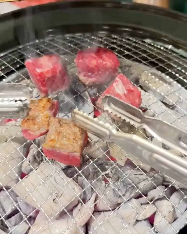 숯불 화로에 구워지는 큐브 모양의 고기