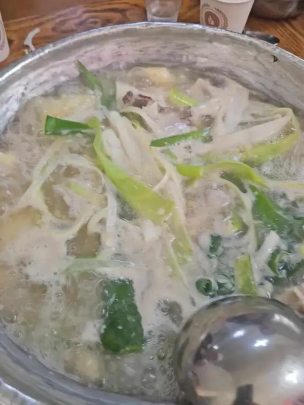 국자로 닭한마리 국물을 뜨는 모습