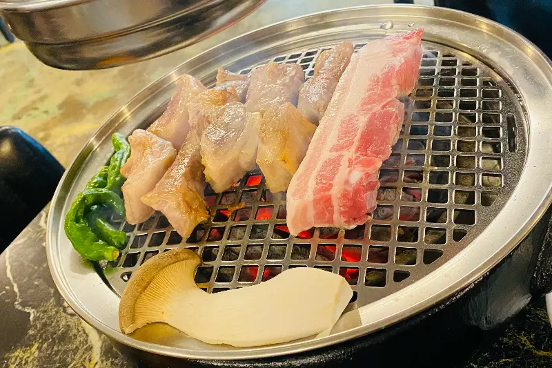 불판 위에 놓인 등겹살, 삼겹살, 그리고 꽈리고추