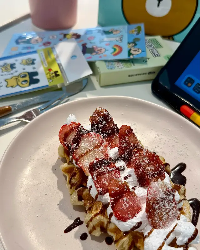 와플 위에 딸기와 생크림이 듬뿍 올라간 디저트