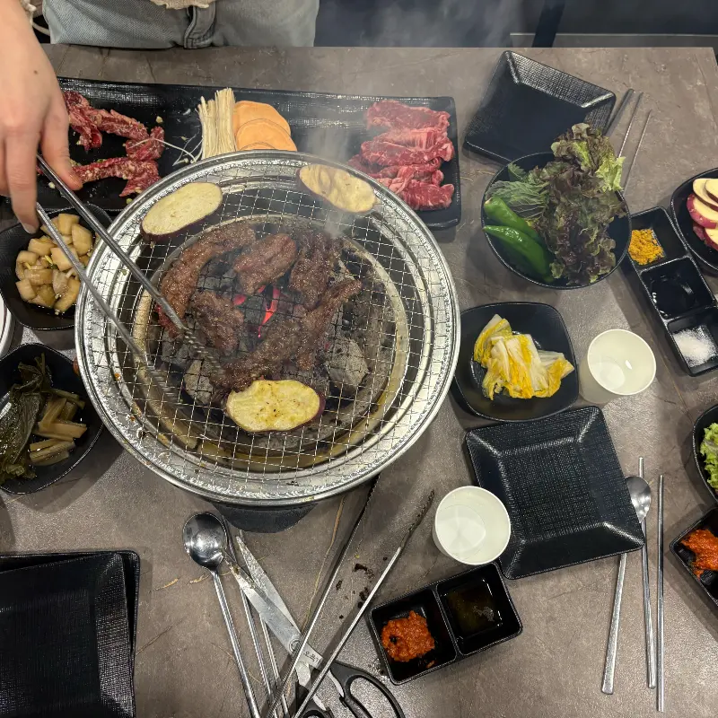 다양한 밑반찬과 고기를 함께 즐기는 모습