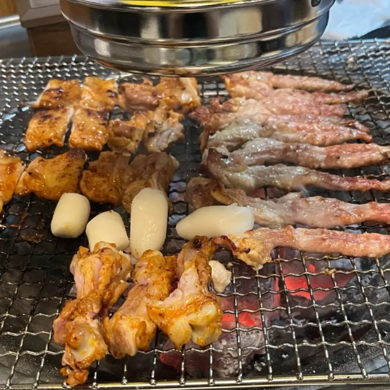 숯불 위에서 맛있게 구워지고 있는 닭갈비와 떡