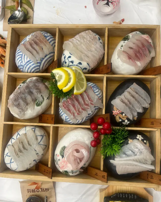 9가지 종류의 신선한 활어회가 담긴 나무 상자