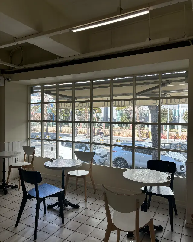 넓은 창가 좌석이 빛이 잘 들어오는 카페 내부