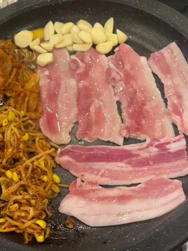 삼겹살, 김치, 마늘을 함께 구워먹는 모습