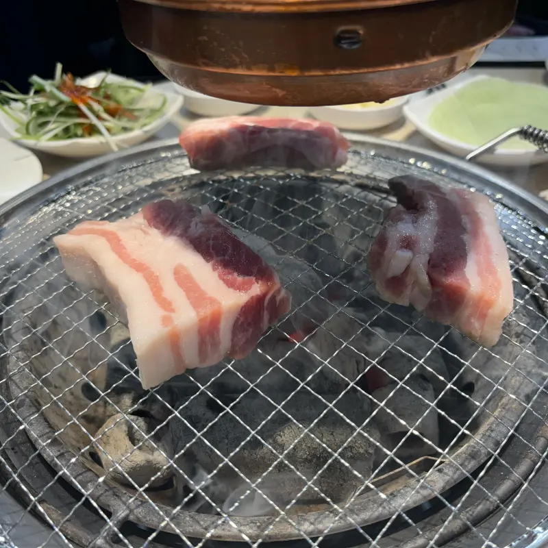 숯불 위에서 맛있게 구워지고 있는 삼겹살