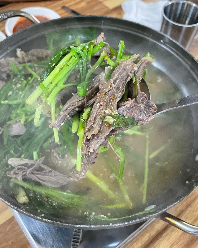 국자로 떠올린 흑염소 고기와 부추