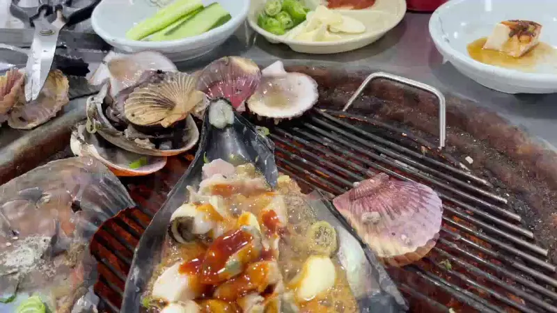 조개구이와 함께 제공되는 다양한 곁들임 메뉴