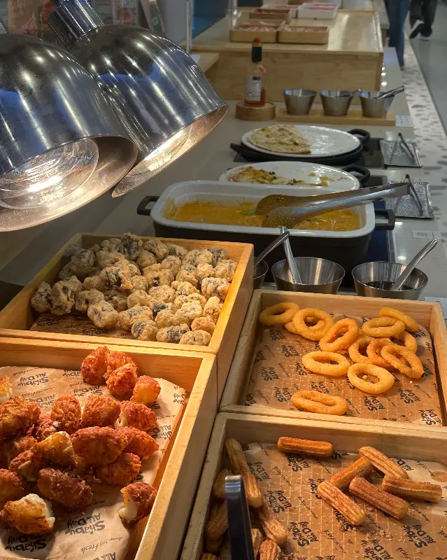 샐러드바에 놓인 튀김, 피자 등 다양한 음식들