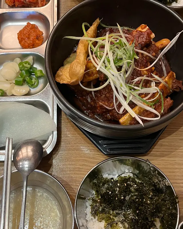 갈비찜과 밥, 반찬이 정갈하게 담겨 있는 모습