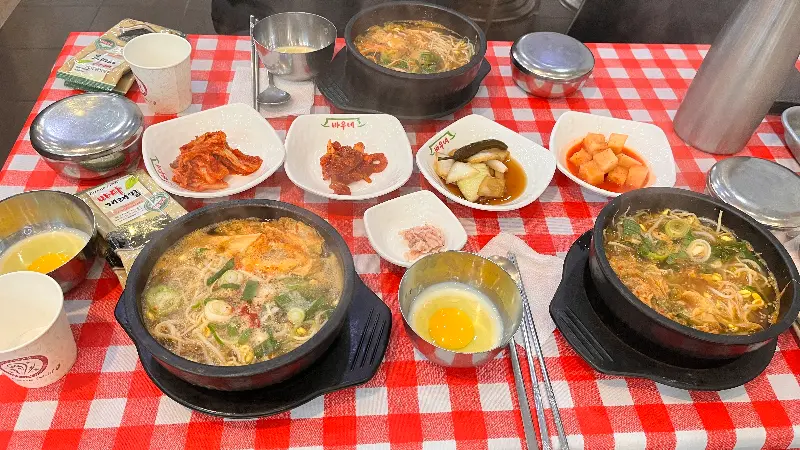 다양한 밑반찬과 곰탕, 육개장이 차려진 테이블 전경