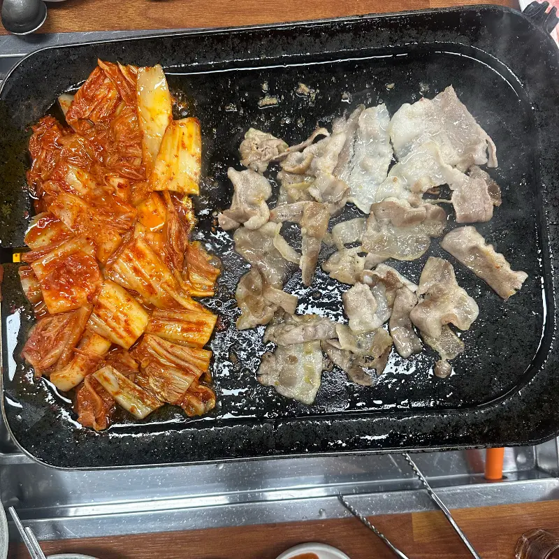 불판 위에서 구워지는 삼겹살과 김치